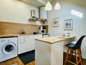 een keuken met een wasmachine en een aanrecht bij Appartement calme et spacieux, tout équipé in Saint-Quentin