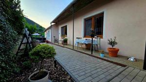 un patio de una casa con mesa y plantas en Apartmány Magnólia Štítnik, en Otilia
