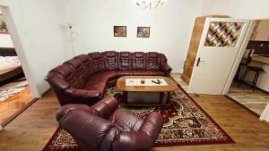 a living room with a leather couch and a coffee table at Apartmány Magnólia Štítnik in Štítnik