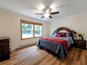 a bedroom with a bed and a ceiling fan at Lakeside Retreat 2hrs from Boston in Stoddard