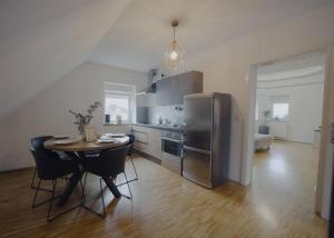 a kitchen with a table and a stainless steel refrigerator at Rezidenca Vista Lux in Ptuj