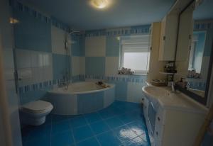 a blue and white bathroom with a tub and a toilet at Rezidenca Vista Lux in Ptuj +26 photos