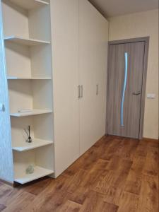 an empty room with a door and a wooden floor at Квартира посуточно на ЮЖД in Kharkiv