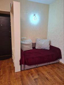 a bed in a room with a light on the wall at Квартира посуточно на ЮЖД in Kharkiv