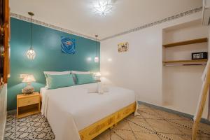 a bedroom with a large white bed and a blue wall at Riad Dar Z'r in Marrakesh