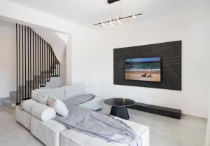 un soggiorno con un divano e una TV a parete di Euphoria Blue Lefkada a Città di Lefkada