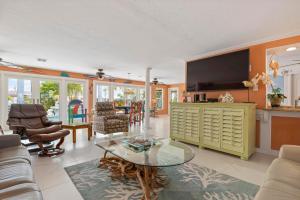 un soggiorno con tv e tavolo di Waterfront Paradise a Holmes Beach