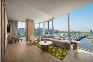 a living room with a couch and tables and windows at Holiday Inn Beihai Silver Beach in Beihai