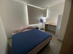 a small bedroom with a blue bed in a room at Estancia mágica al lado del cc fabricato in Bello