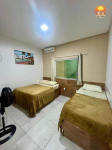 una camera d'albergo con due letti e una finestra di Casa em Paripueira, conforto e privacidade a Paripueira