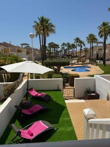 a patio with two chairs and an umbrella at Casa Flamingo in Ciudad Quesada