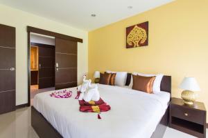 a bedroom with a bed with two stuffed animals on it at The Lai Thai Luxury Condominiums in Ao Nang Beach