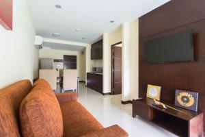 a living room with a couch and a flat screen tv at The Lai Thai Luxury Condominiums in Ao Nang Beach