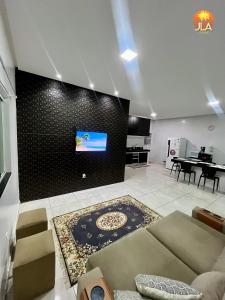 un soggiorno con un divano e una TV a parete di Casa em Paripueira, conforto e privacidade a Paripueira
