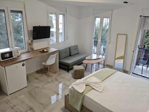 a bedroom with a bed and a desk and a couch at Kleio Pythagorio Studio in Pythagoreio