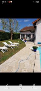 a patio with lounge chairs and a swimming pool at Le bureau in Digoin