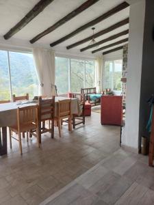 a dining room with a table and chairs and a living room at Casa en el Siambon in Siambón