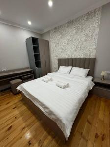 a bedroom with a large white bed with towels on it at Hotel 002 in Osh +29 photos