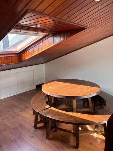 a wooden table and bench in an attic at El rincón de Carolina in O Barqueiro