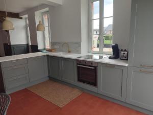 a kitchen with white cabinets and a sink at Maison Louise - Gîte de charme entre forêt et étang - Family friendly 