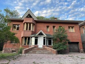 a red brick house with a white door at Гостевой дом Ласточка 2 in Almaty