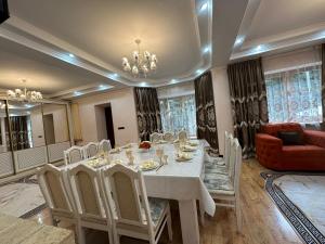 a dining room with a table and chairs and a couch at Гостевой дом Ласточка 2 in Almaty