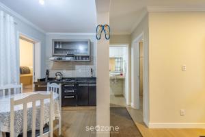 Una cocina y una sala con una mesa y un comedor. en Apto funcional a 120m de la playa en BC | CEC0302, en Balneário Camboriú