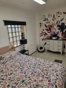 a bedroom with a bed with a flower pattern on the wall at Le bureau in Digoin