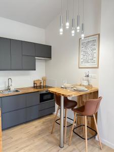 cocina con mesa de madera y sillas en Cozy studio with air conditioning & pool & parking, en Aix-en-Provence