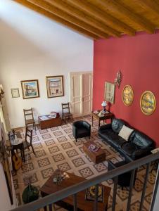 a living room with a couch and a red wall at Al Palazzo in Piazza Armerina