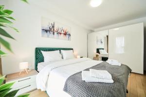 蒂米什瓦拉Central Accommodation in Monarh Tower by Open House apartments的卧室里有一张白色的大床，床上有两条毛巾