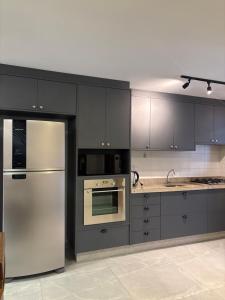 a kitchen with stainless steel appliances and gray cabinets at Casa Privativa Prox Expoville e Centro Com 2 Suítes in Joinville