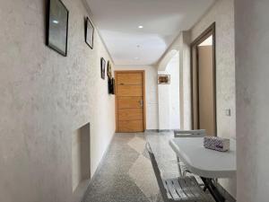 a dining room with a table and chairs and a door at Appartement arome in Rabat