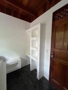 サマラにあるWoodstock Hostelの白い棚と木製のドアが備わる部屋