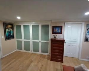 ein Wohnzimmer mit weißen Schränken und Holzboden in der Unterkunft Los Colibries in Mexiko-Stadt