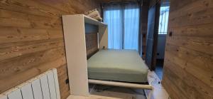 a room with a bed in a wooden wall at Studio in Grignon