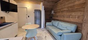 a living room with a blue couch and a table at Studio in Grignon