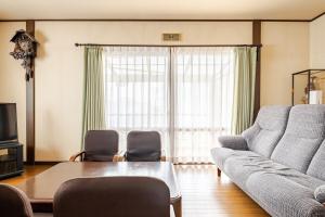 a living room with a couch and a table at グループ宿泊に最適 Spacious Home Base by Yadoya in Yokkaichi