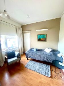 un dormitorio con una cama y una silla en Snygg studio lägenhet Wolffskavägen 21, en Vaasa