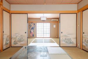 a room with doors and paintings on the walls at グループ宿泊に最適 Spacious Home Base by Yadoya in Yokkaichi +35 photos