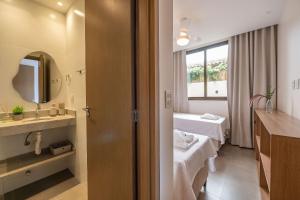 バーハ・グランデにあるSeu refúgio à poucos passos da Praia e da Vila!の病室にはベッド2台と鏡が備わります。 +21枚の写真