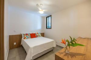 バーハ・グランデにあるSeu refúgio à poucos passos da Praia e da Vila!のベッドとテーブルのある小さな寝室