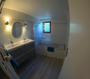 ein Badezimmer mit Badewanne, Waschbecken und Spiegel in der Unterkunft La Belmontine Maison avec jardin Uriage-les-Bains in Vaulnaveys-le-Haut + 17 Fotos