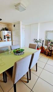 a dining room with a green table and chairs at Apartamento com 2 quartos próximo aCastelão Arena in Fortaleza +2 photos