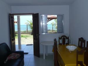 Sala de estar con mesa y vistas al océano en Privê Areias Douradas en Peroba