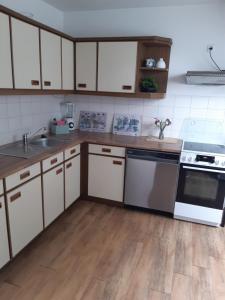 a kitchen with white appliances and wooden floors at Auf dem Lande in Weener