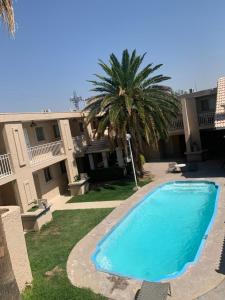 a pool in front of a building with a palm tree at Condomino Maripina in Arena