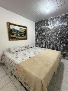 a bedroom with a bed with a painting on the wall at Apartamento no Centro in Manaus