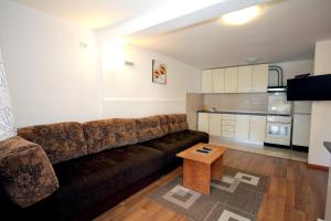 a living room with a brown couch and a table at Apartments Kojic in Bar
