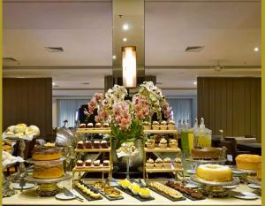 a buffet of desserts and cakes on a table at Flat Mont Blanc Premium in Ribeirão Preto